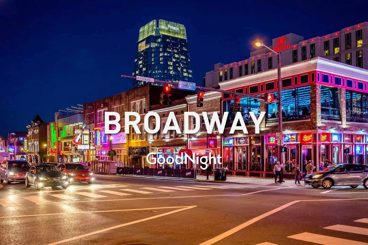 This exterior shot captures a bustling nightlife scene on a busy Nashville street, with neon signs, illuminated buildings, and crowds of people enjoying dining, entertainment, and shopping. The streets glow with energy and excitement, evoking the iconic feel of Broadway and Nashville's vibrant music scene.