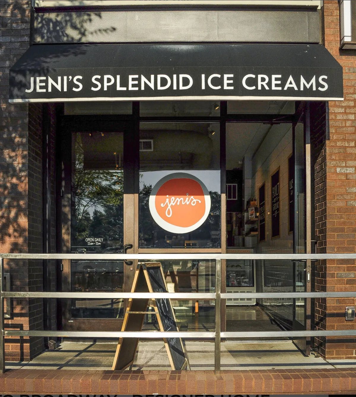 The exterior of Eskimo Joe’s Ice Cream shop showcases a cheerful storefront, inviting entrance, and outdoor seating—evoking the delight of grabbing a treat after a day of local exploration. The mood is light and welcoming, perfect for family outings.